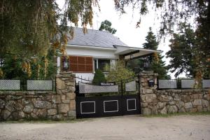 a white house with a stone fence and a garage at Villa Karina in Valdemanco
