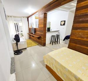 a bedroom with a bed and a kitchen with a counter at CASA COMPLETA 5min DA PRAIA JUQUEHY in São Sebastião