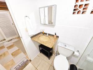 a white bathroom with a sink and a toilet at CASA COMPLETA 5min DA PRAIA JUQUEHY in São Sebastião