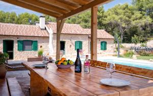 einen Holztisch mit einer Flasche Wein und Gläsern in der Unterkunft Old Town Villa Hvar in Basina