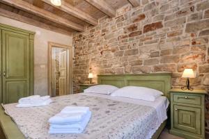 ein Schlafzimmer mit einem Bett mit Handtüchern darauf in der Unterkunft Old Town Villa Hvar in Basina + 25 Fotos
