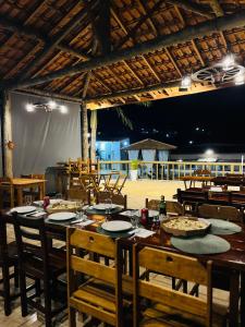 un comedor con mesa, sillas, mesa y sillón en Prime Garden Pousada, en Socorro