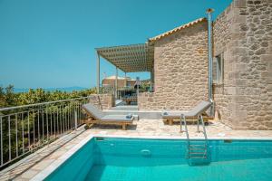 a villa with a swimming pool and a house at Elia Villas in Riglia