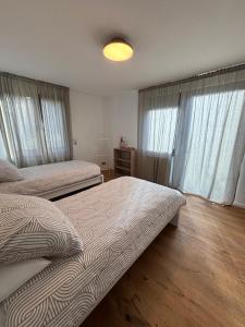 1 Schlafzimmer mit 2 Betten und Fenstern mit Vorhängen in der Unterkunft Ruhige Ferienwohnung im Schwarzwald in Schramberg
