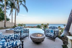 a patio with chairs and a fire pit next to a pool at Villa Pura Vida in San José del Cabo