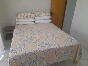 Cama en habitación con colcha y almohadas en Encanto de Tatuamunha, en Porto de Pedras