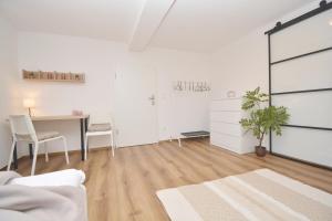 Sala de estar blanca con escritorio y mesa en CO11 - Ferienwohnung in Coburg, en Coburg