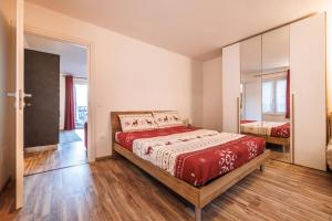 a bedroom with a bed with a red comforter at Casa Adamello in Corteno Golgi