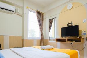 Una televisión o centro de entretenimiento en Sans Hotel Havila Bengkulu