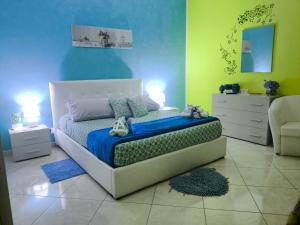 1 dormitorio con 1 cama con paredes azules y verdes en Light Blue Room, en Scordia