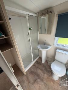 a bathroom with a shower and a toilet and a sink at Sunnymede D1 - Hot Tub Caravan - Sleeps 10 - Fantasy Island, Ingoldmells - Meadow Lakes Caravan & Lodge Hire in Ingoldmells