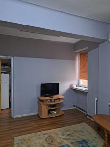 an empty living room with a television and a table at Garsoniera in inima Targului de Craciun in Craiova