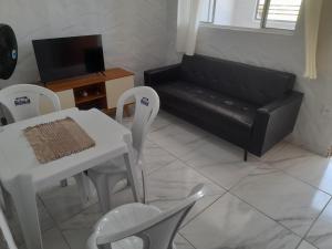 Una sala de estar con un sofá, una mesa y sillas. en Encanto de Tatuamunha, en Porto de Pedras