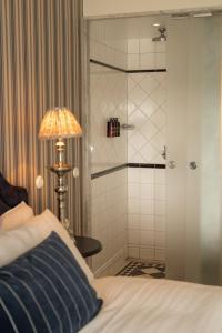 ein Schlafzimmer mit einem Bett, einer Dusche und einer Lampe in der Unterkunft Ystad Saltsjöbad in Ystad