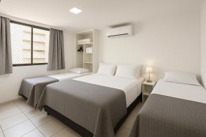 a bedroom with two beds and a window at Atlantic Ocean Residence in Fortaleza