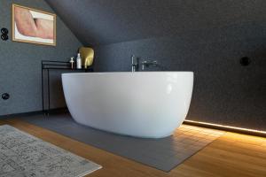 a bathroom with a large white tub in a room at Rest Hill -Domek z balią i sauną - Everslow in Sosnówka +20 photos