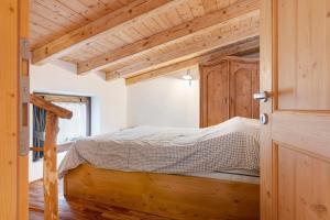 a bedroom with a bed in a room with wooden ceilings at Mansarda di charm Valli di Borzago in Mortaso