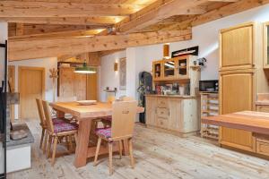 a kitchen with a wooden table and chairs at Mansarda di charm Valli di Borzago in Mortaso