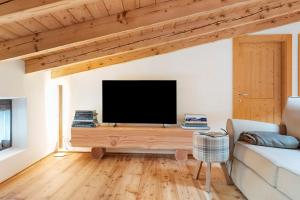 a living room with a tv and a couch at Mansarda di charm Valli di Borzago in Mortaso
