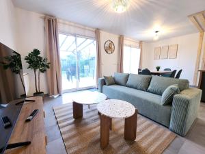 a living room with a couch and a table at Le Plaisance de Mérignac in BOD