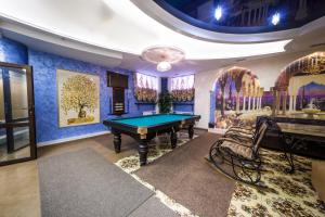 a pool table in a room with blue walls at Hotel Khalif in Tomsk