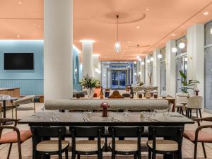 ein Esszimmer mit Tisch und Stühlen in der Unterkunft Hotel Lycium Debrecen - Handwritten Collection in Debrecen