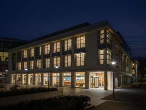 ein großes Gebäude mit vielen Fenstern in der Nacht in der Unterkunft Hotel Lycium Debrecen - Handwritten Collection in Debrecen