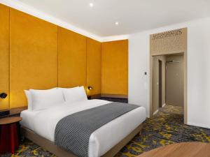 ein Schlafzimmer mit einem großen weißen Bett und gelben Wänden in der Unterkunft Hotel Lycium Debrecen - Handwritten Collection in Debrecen + 89 Fotos