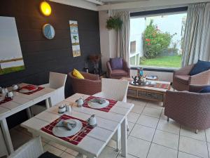 Un comedor con mesas y sillas y una ventana. en Pebble Stone House Bed & Breakfast, en Swakopmund