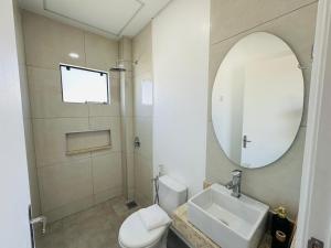 a bathroom with a sink and a toilet and a mirror at Alojamiento Del Lago in Cambyretá