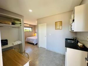 a room with a kitchen and a bedroom with a bed at Alojamiento Del Lago in Cambyretá