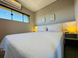 a bedroom with a large white bed with a window at Alojamiento Del Lago in Cambyretá