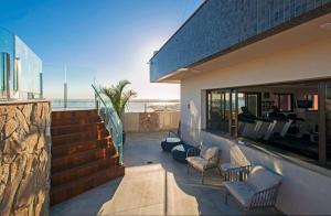 a balcony of a house with chairs and a staircase at Intercity Porto Alegre Praia de Belas in Porto Alegre