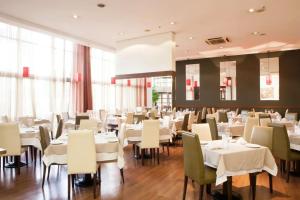 a dining room with white tables and chairs at Intercity Porto Alegre Praia de Belas in Porto Alegre