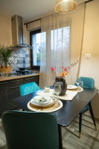 a dining room table with plates and glasses on it at Pipera Studio Apartment in Voluntari