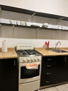 a kitchen with a stove and a sink at Antigua Encantó Colonial in Antigua Guatemala