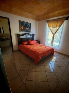 a bedroom with a bed with red sheets and a window at Antigua Encantó Colonial in Antigua Guatemala +12 photos
