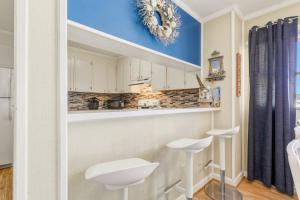 a kitchen with white cabinets and a blue wall at AV2-3E - Don't Blink in Croatan Shores