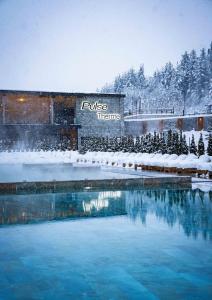 einen Pool mit Wasser vor einem Gebäude im Schnee in der Unterkunft Grand Hotel Therme in Banya