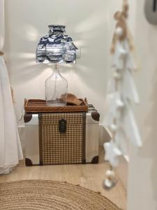 ein Glasgefäß, das auf einer Weidenkiste steht in der Unterkunft Ana´s House in Setúbal