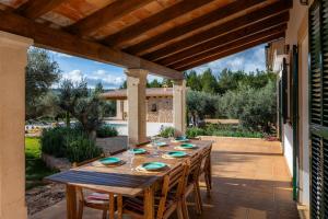 een houten tafel met stoelen op een patio bij Ca na Barons in Bunyola