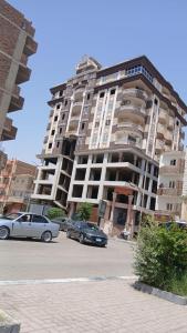 zwei Autos parkten vor einem großen Gebäude in der Unterkunft Dreams House in Luxor