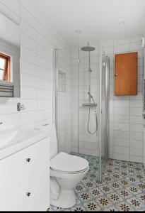 Un baño blanco con inodoro y ducha. en Sjöutsikt Sövde, en Sövde