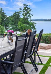 una mesa de madera con copas de vino en el patio en Sjöutsikt Sövde, en Sövde
