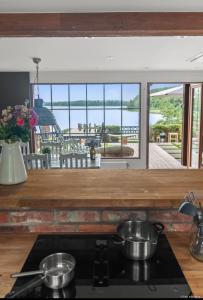 una cocina con 2 ollas en una estufa en Sjöutsikt Sövde, en Sövde 27 fotos más