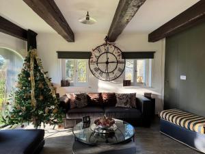a living room with a christmas tree and a large clock at Rest & Relax Doubice in Doubice