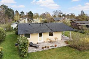 a small white house with a deck in a yard at 3004-Stege-Paelen-21 in Stege