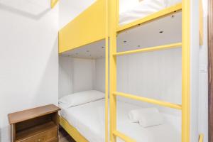 a room with a bunk bed and a desk at Hostdomus - Yellow Suite in Sestriere