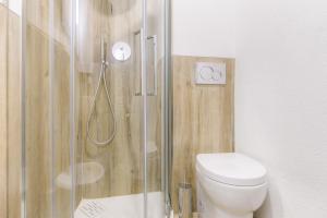 a bathroom with a toilet and a glass shower at Hostdomus - Yellow Suite in Sestriere