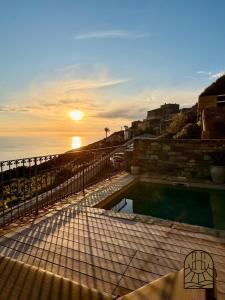 a sunset over a swimming pool with the ocean at Cap Helios l ecrin corse a couper le souffle in Morsiglia